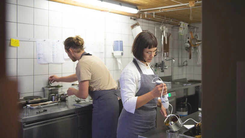 Rebecca Clopath in ihrer Küche mit Teammitglied Ruben im Hintergrund.