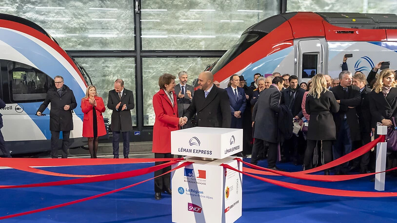 Bundesrätin Simonetta Sommaruga und der französische Botschafter in der Schweiz, Frédéric Journès, reichen sich bei der Einweihungsfeier für den neuen Léman Express am Donnerstag in Genf die Hand. (KEYSTONE/Martial Trezzini)