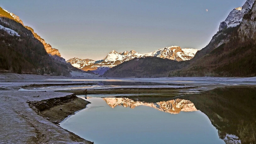 Auf der Höhe des Bärentritts staut sich das Wasser der Chlü und fliesst gemächlich in den See. Kurz danach hat sich bis zum Rhodannenweg Eis gebildet. Auf dem Bild «Froni», Mürtschenstock und Schilt in Abendstimmung.