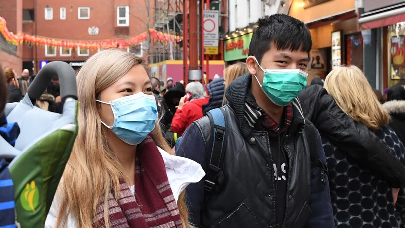 Fussgänger mit Masken in der Londoner Chinatown. In der Schweiz gibt es vorderhand keine bestätigten Infektionen mit dem neuartigen Coronavirus. (Themenbild)