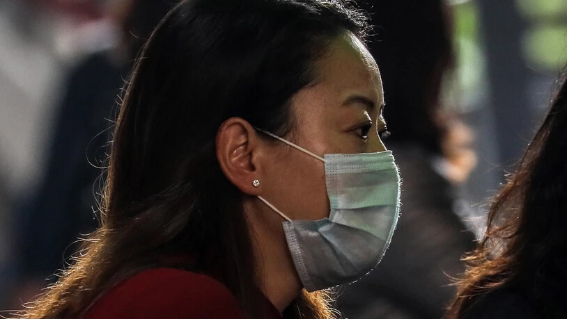 Eine Person schützt sich mit einer Gesichtsmaske vor einer möglichen Ansteckung mit dem Coronavirus. (Symbolbild)