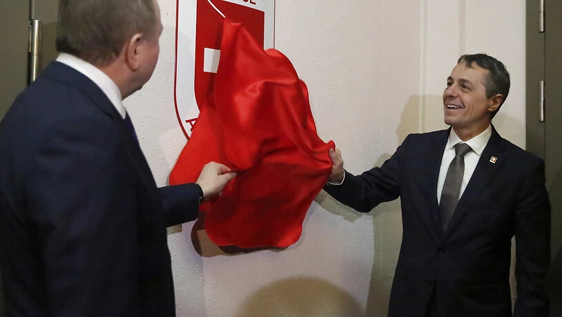 Aussenminister Ignazio Cassis (rechts) enthüllt das Schweizer Wappen an der Schweizer Botschaft in Minsk.