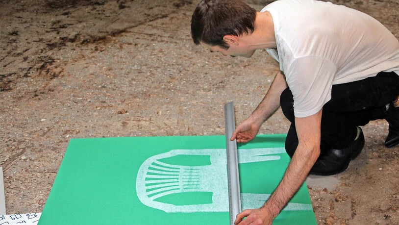 Massarbeit: Für den zweiten Druckvorgang misst Dafi Kühne die richtigen Abstände aus. Vom Endresultat ist das Plakat noch weit entfernt.