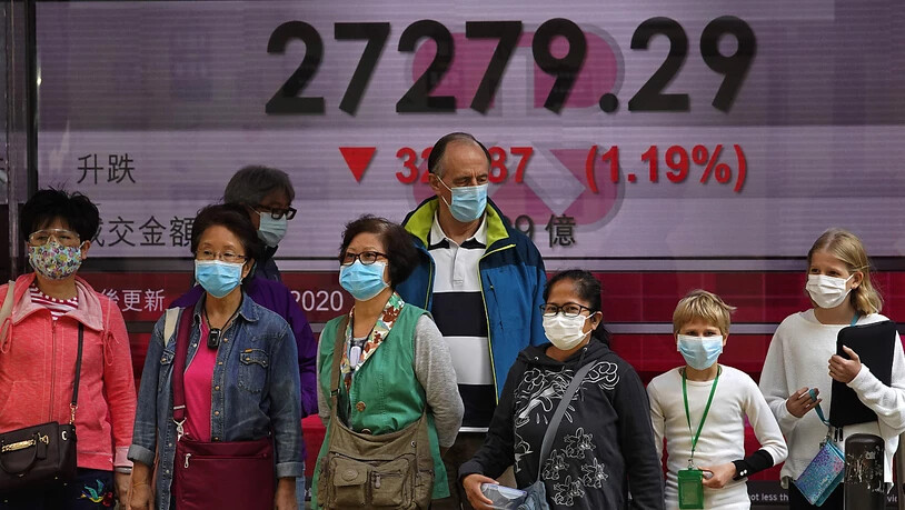 Die Furcht vor dem Coronavirus kommt nun immer stärker an den Börsen an - im Bild Passanten vor der Hong Kong Stock Exchange. (Archiv)