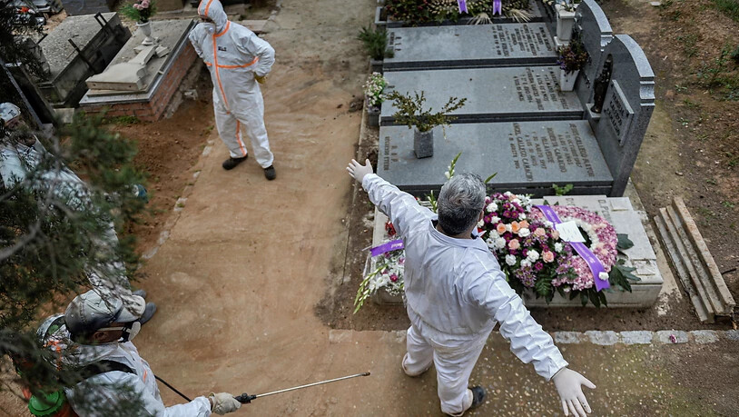 Desinfizieren auf dem Friedhof: Ein städtischer Angestellter desinfiziert einen Kollegen nach einer Beerdigung in Guadalajara.