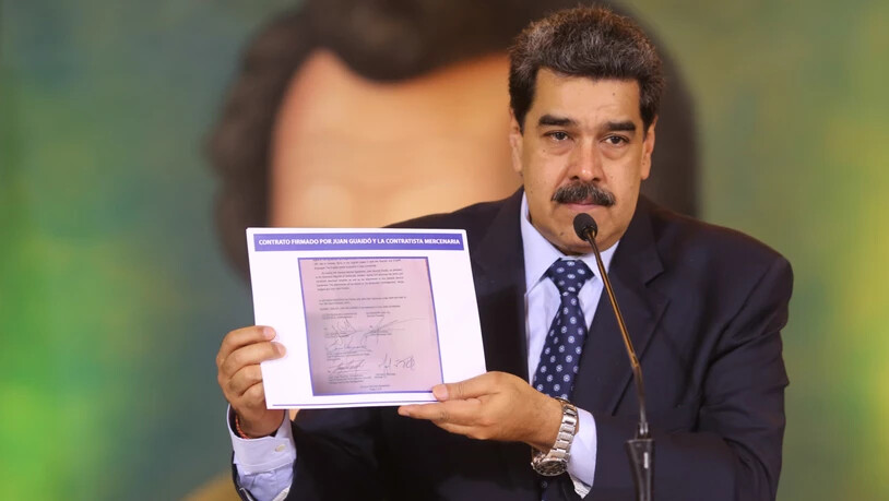 HANDOUT - Auf diesem vom venezolanischen Präsidentenamt zur Verfügung gestellten Bild zeigt Nicolas Maduro, Präsident von Venezuela, die Kopie eines Dokumentes, das beweisen soll, dass der Oppositionsführer Guaido einen angeblichen Invasionsversuch mit …