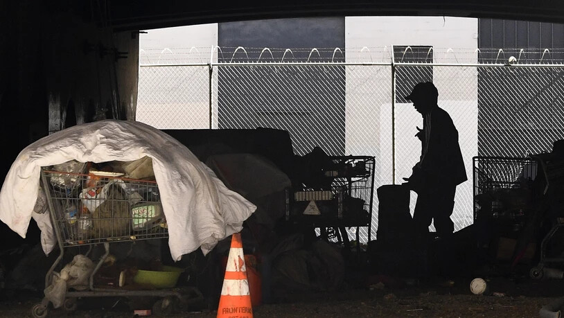 ARCHIV - Ein Mann steht auf einem Obdachlosenlager unter der Interstate 110 in der Nähe der Ramirez Street in der Innenstadt von Los Angeles. Foto: Mark J. Terrill/AP/dpa