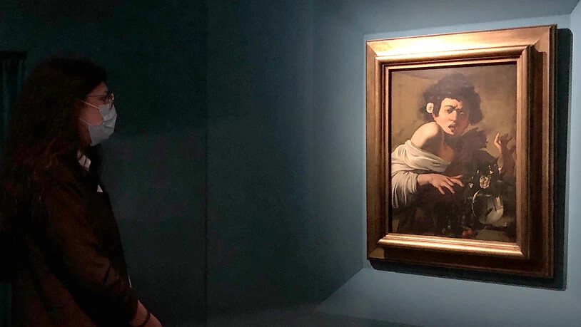 Ein Frau vor dem Gemälde «Jüngling, von einer Eidechse gebissen» von Michelangelo Merisi da Caravaggio in der Sonderausstellung in den Kapitolinischen Museen. Foto: Alvise Armellini/dpa - ACHTUNG: Nur zur redaktionellen Verwendung im Zusammenhang mit…
