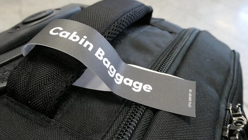 ARCHIV - Ein Anhänger mit der Aufschrift "Cabin Baggage" (Kabinengepäck) am Haltegriff eines kleinen Koffers. Foto: Andrea Warnecke/dpa-tmn/dpa