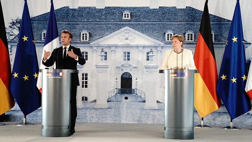 Bundeskanzlerin Angela Merkel und Frankreichs Präsident Emmanuel Macron sprechen nach ihrem Treffen im Schloss Meseberg in Brandenburg. Foto: Kay Nietfeld/dpa-Pool/dpa