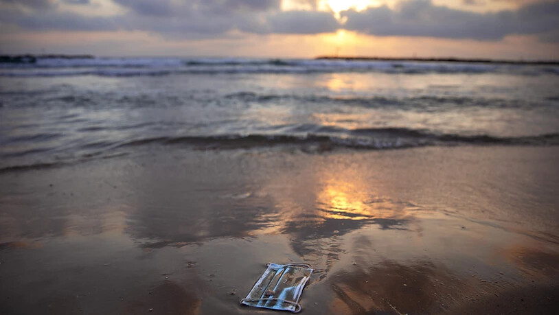 Ein Mundschutz liegt am Strand von Tel Aviv. Foto: Oded Balilty/AP/dpa