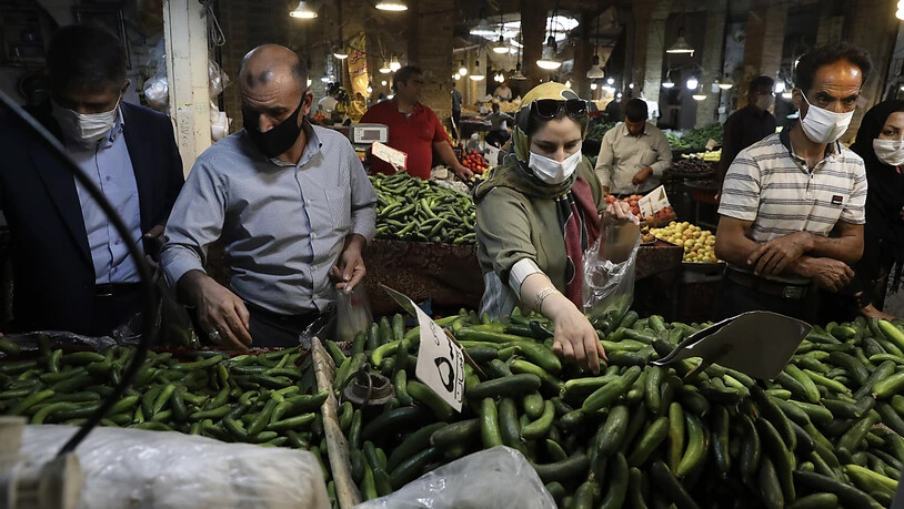 Kunden mit Schutzmasken kaufen Gemüse auf dem Basar von Zandschan ein. Wegen des dramatischen Anstiegs der Anzahl der täglichen Corona-Toten und Neuinfektionen hat Präsident Ruhani eine Maskenpflicht in Behörden, im öffentlichen Nahverkehr sowie aufn…