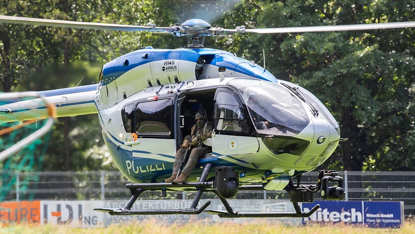 Ein Hubschrauber der Polizei landet nahe der Gemeinde Oppenau auf einem Sportplatz, welcher der Polizei als Sammelpunkt dient. Foto: Philipp von Ditfurth/dpa
