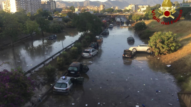 HANDOUT - Autos stecken im Wasser und Schlamm fest, nachdem eine Unterführung überflutet wurde. Ein schweres Sommerunwetter hat Teile der sizilianischen Stadt Palermo unter Wasser gesetzt. Der stundenlange Regen verwandelte Straßen in Flüsse. Foto:…