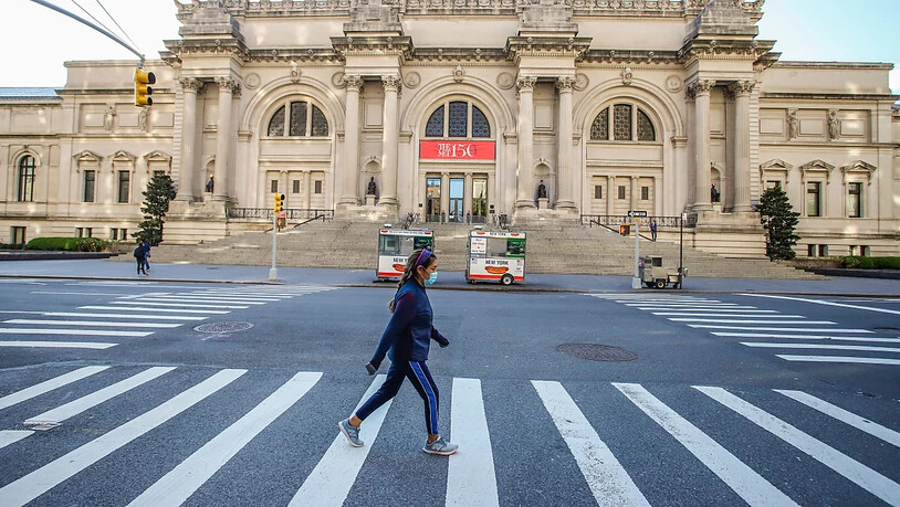 ARCHIV - Eine Frau mit Mundschutz geht vor dem Metropolitan Museum of Art in New York über die Straße. Foto: Vanessa Carvalho/ZUMA Wire/dpa