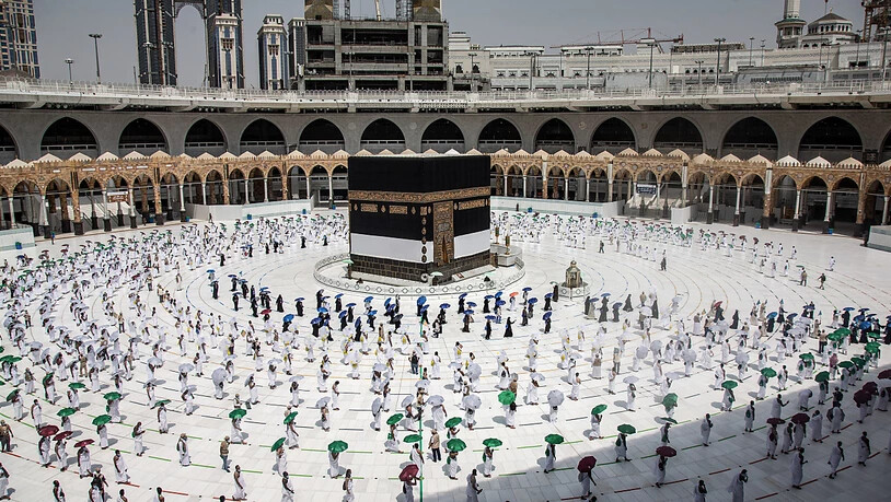 HANDOUT - Hunderte von muslimischen Pilgern umkreisen die Kaaba, das kubische Gebäude der Großen Moschee, während sie als Schutz vor der Ansteckung mit dem Coronavirus vor der Hadsch-Pilgerfahrt Abstand beibehalten. Foto: Saudi Ministry of Media/dpa -…