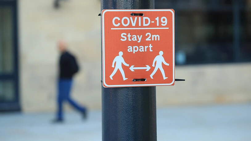 Ein Schild, das eine der Corona-Regeln abbildet, erinnert an die Einhaltung eines Mindestabstands von zwei Metern und ist an einer Laterne fixiert. Foto: Danny Lawson/PA Wire/dpa