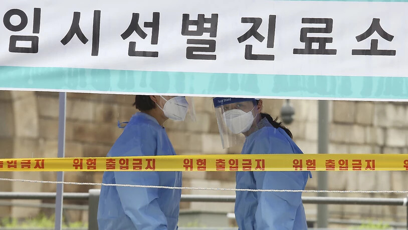 Medizinische Mitarbeiterinnen in Schutzkleidung stehen in einer Einrichtung für Covid-19-Tests in Südkorea. Foto: Ahn Young-Joon/AP/dpa