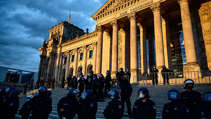 Polizisten stehen bei einem Protest gegen die Corona-Maßnahmen vor dem Reichstagsgebäude. Foto: Fabian Sommer/dpa