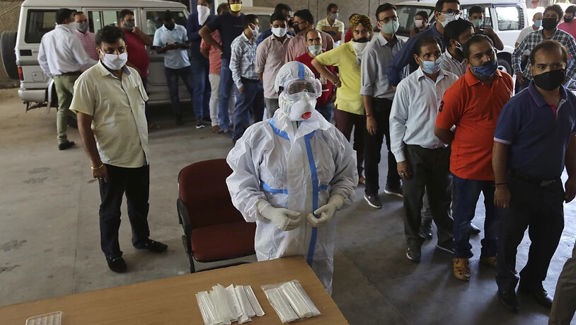 Mitarbeiter einer Universität stehen in der Stadt Jammu Schlange, um sich für einen Corona-Test anzumelden. Indien ist weltweit momentan das am zweitstärksten vom Coronavirus betroffene Land. Foto: Channi Anand/AP/dpa
