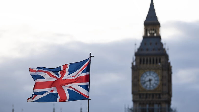 ARCHIV - Die Flagge vom Vereinigtem Königreich (Union Jack) weht im Wind. Im Hintergrund ist der Uhrturm Elizabeth Tower mit dem Big Ben zu sehen. Foto: Monika Skolimowska/dpa-Zentralbild/dpa