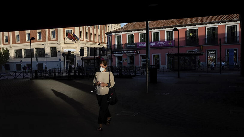Eine Frau mit Gesichtsmaske auf einem Platz in der spanischen Hauptstadt. Foto: Bernat Armangue/AP/dpa