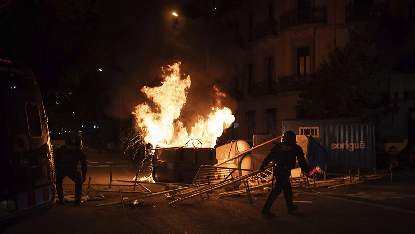 Polizisten entfernen Barrikaden während einer Kundgebung gegen die Enthebung des katalanischen Regionalpräsidenten Torra. Foto: Felipe Dana/AP/dpa