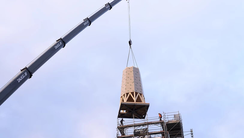 Der erste Teil der Turmspitze wird mit einem Autokran auf den Kirchturm in Herzogenbuchsee montiert. Der Kirchturm war an Heiligabend 2019 durch einen Brand zerstört worden.