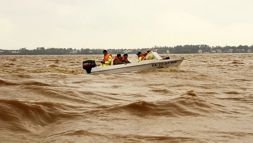 Rettungskräfte fahren mit einem Boot über überflutetes Gebiet in Quang Binh. Foto: Nguyen Van Ty/VNA/AP/dpa