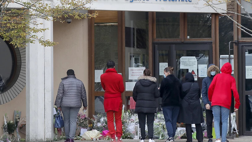 Schüler gedenken vor einer Schule dem Lehrer, der bei einer mutmaßlich terroristisch motivierten Tat ermordet wurde. Foto: Michel Euler/AP/dpa