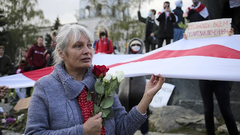 dpatopbilder - Eine Frau hält bei einer Demonstration Rosen und die historische weiß-rot-weiße Fahne in der Hand. Tausende Menschen, darunter vor allem Senioren und Studenten, marschierten am Montag durch die Hauptstadt. Foto: -/AP/dpa