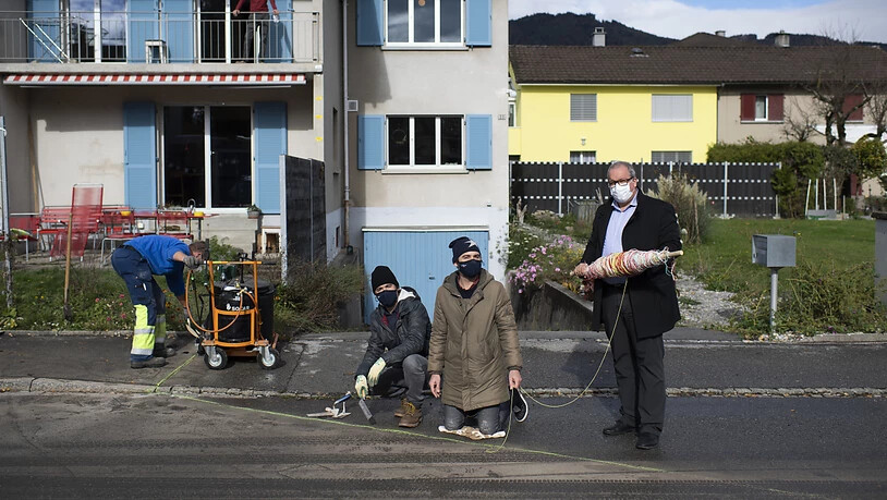 Schnüre statt Glasfasern: Die Konzeptkünstler Frank (Mitte) und Patrik Riklin sowie Stadtpräsident Ruedi Mattle (rechts) bei der Verlegung des "Analogen Fadennetzes".