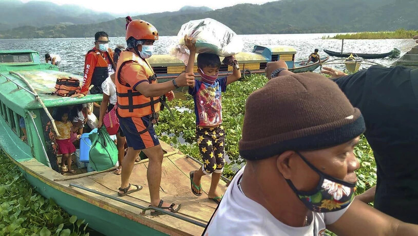 HANDOUT - Auf diesem von der philippinischen Küstenwache zur Verfügung gestellten Foto werden Familien von Mitgliedern der philippinischen Küstenwache auf sichereren Boden in der Provinz Camarines Sur im Osten der Philippinen gebracht, während sie sich…