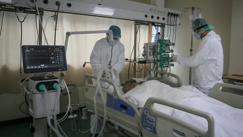 Medizinische Mitarbeiter in Schutzausrüstung versorgen einen im Bett liegenden Corona-Patienten auf der Intensivstation des Krankenhauses der Rafik-Hariri-Universität. Foto: Marwan Naamani/dpa