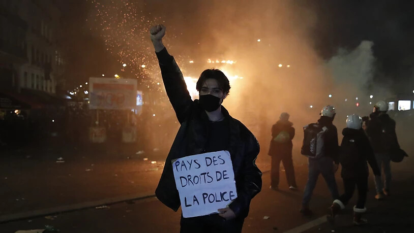 Ein Teilnehmer einer Demonstration hält während eines Protestes gegen ein neues Sicherheitsgesetz ein Schild mit der Aufschrift «Land der Polizeirechte» in der Hand. Foto: Francois Mori/AP/dpa