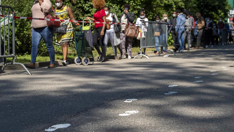 Menschen stehen in Genf Schlange, um gratis Nahrungsmittel und Bedarfsartikel für den Alltag zu erhalten. (Archiv)