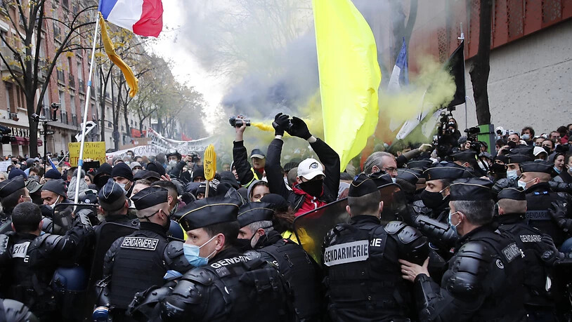 Polizisten blockieren Demonstranten bei einem Protest gegen Polizeigewalt und Rassismus. Der Protest bezieht sich auf Aufnahmen eines Vorfalls im vergangenen Monat, bei dem Polizisten einen Schwarzen geschlagen haben sollen. Foto: Francois Mori/AP/dpa