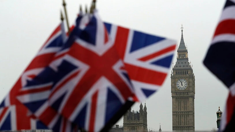 ARCHIV - Britische Flaggen wehen in der Nähe des berühmten Uhrturms Big Ben. Der Uhrturm ist Teil des Palace of Westminster, in dem das britische Parlament tagt. Foto: Matt Dunham/AP/dpa