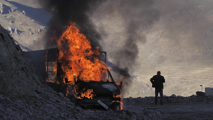 ARCHIV - Ein brennendes Auto nahe der Grenze zwischen Berg-Karabach und Armenien. Foto: ---/AP/dpa