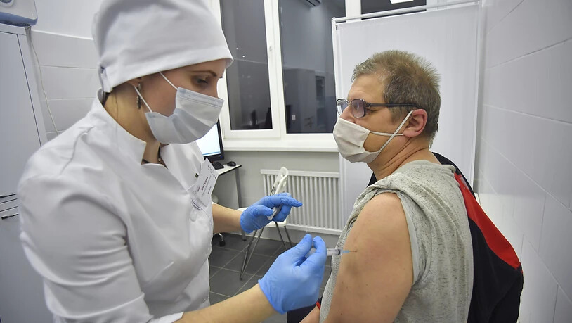 Eine medizinische Mitarbeiterin verabreicht einem Mann den Corona-Impfstoff Sputnik V. Foto: Sergey Kiselev/Moscow News Agency/AP/dpa