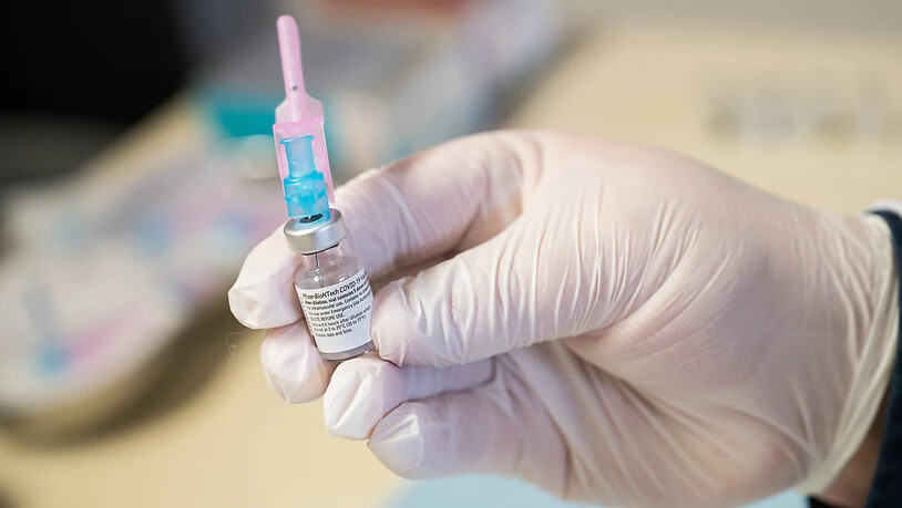 Ein Mitarbeiter des Westpfalz-Klinikums hält ein Fläschchen mit dem Impfstoff gegen Covid-19 in der Hand. Foto: Oliver Dietze/dpa