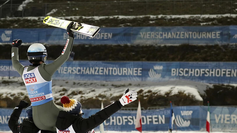 Die Teamkollegen heben Stoch vor leerer Tribüne auf ihre Schultern.