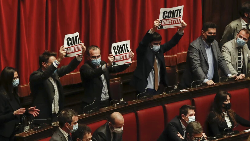 Protest vor dem Vertrauensvotum: Abgeordnete halten während einer Rede von Italiens Ministerpräsident Conte Plakate mit der Aufschrift «Conte, tritt zurück» in die Höhe. Foto: Alessandra Tarantino/AP/dpa