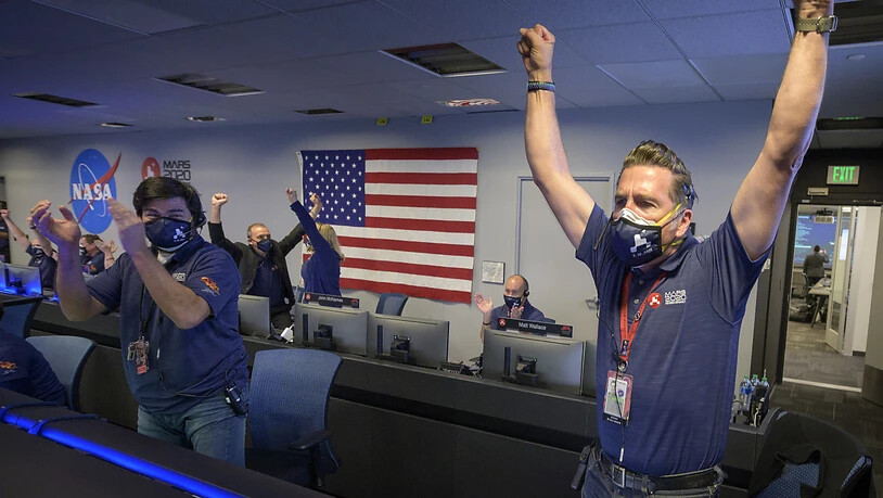 dpatopbilder - HANDOUT - Mitarbeiter des Perseverance-Rover-Teams der NASA jubeln in der Missionskontrolle, nachdem sie die Bestätigung erhalten haben, dass das Raumfahrzeug erfolgreich auf dem Mars gelandet ist. Foto: Bill Ingalls/NASA/dpa - ACHTUNG:…