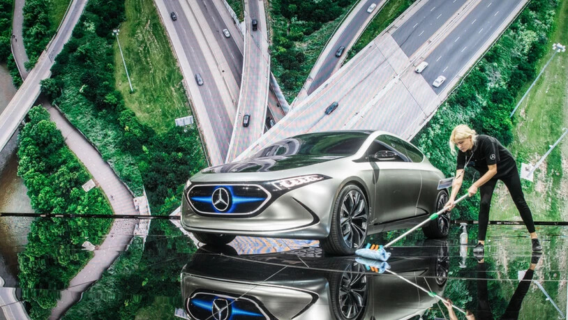Saubere Sache: Eine Raumpflegerin wischt 2017 an einem Messestand von Mercedes unter einem Elektro-Konzept-Fahrzeug namens EQ A. Das Auto gibt's inzwischen serienmässig. Und Daimler erwägt, bis 2030 alle Modelle CO2-frei zu machen, berichtet ein…