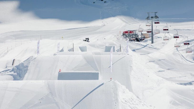 Im Corvatschpark fliegen Skifahrer und Snowboarder über hohe Kicker.