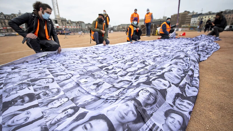 Die "We are watching"-Fahne setzt sich aus Tausenden von Porträts aus aller Welt zusamen. Quelle: KEYSTONE Fotograf: MARTIAL TREZZINI