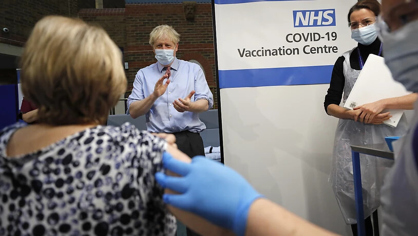 ARCHIV - Boris Johnson (M), Premierminister von Großbritannien, applaudiert, nachdem die Krankenschwester Rebecca Cathersides (r) zu Beginn der britischen Impfkampagne den Pfizer-BioNTech Corona-Impfstoff an Lyn Wheeler (l) im Guy's Hospital verabreicht…
