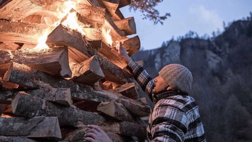  Fleissige Helfer: Am Nachmittag schichten Helfer den Holzstapel auf. Der Lohn für die Arbeit: Einer von ihnen darf das Feuer auch entfachen.