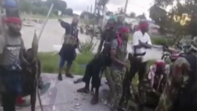 SCREENSHOT - Mutmaßliche Kämpfer, die in der nordmosambikanische Küstenstadt wüteten, sind versammelt. Nach den tagelangen Kämpfen werden immer mehr Details über das brutale Vorgehen der Angreifer bekannt. Foto: Amaq/Militant video/AP/dpa - ACHTUNG: Nur…